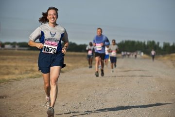 abbigliamento adatto per la corsa - donna che corre sull'asfalto